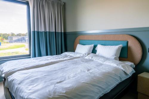 a large bed in a bedroom with a window at Stopover Falkenberg in Falkenberg