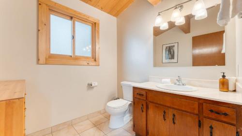a bathroom with a sink and a toilet and a mirror at Tahoe Timber by AvantStay Beach Lake Access in Homewood
