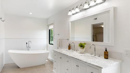 a white bathroom with a large tub and a sink at Edendale by AvantStay Urban Hilltop Oasis w Amazing Views in 3 of Los Feliz in Los Angeles
