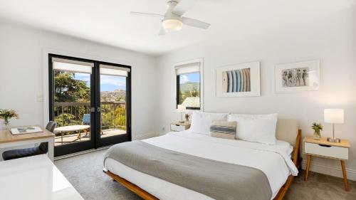 a white bedroom with a bed and a balcony at Edendale by AvantStay Urban Hilltop Oasis w Amazing Views in 3 of Los Feliz in Los Angeles