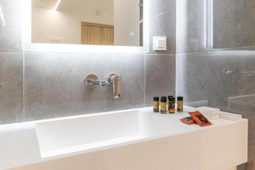 a bathroom with a white sink and a mirror at Epavli Grace Hotel in Chania Town