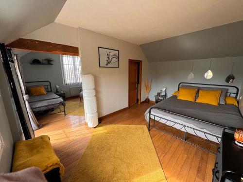 a bedroom with a large bed with yellow pillows at Gîte dans un petit haras in Mézidon