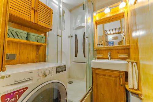 une petite salle de bains avec lave-linge et lavabo dans l'établissement Enjoy Charming Machu, à Val Thorens