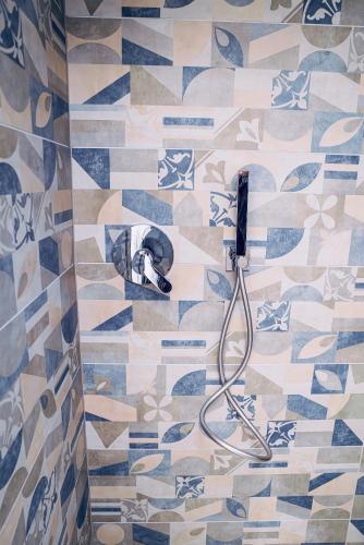 a shower with a blow dryer on a tiled floor at ViKo35Como in Como