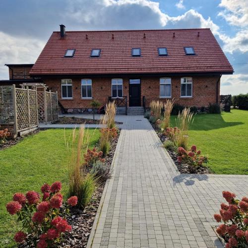 a brick house with a walkway in front of a yard at Stara Szkola - Wielki Medromierz 59 in Wielki Modromierz