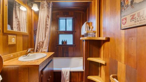 a bathroom with a bath tub and a sink at Riversong Lodge by AvantStay Sauna Hot Tub On The Truckee River in Truckee