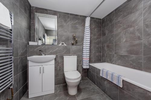 a bathroom with a toilet and a sink and a tub at Triple B Aparto in Clacton-on-Sea