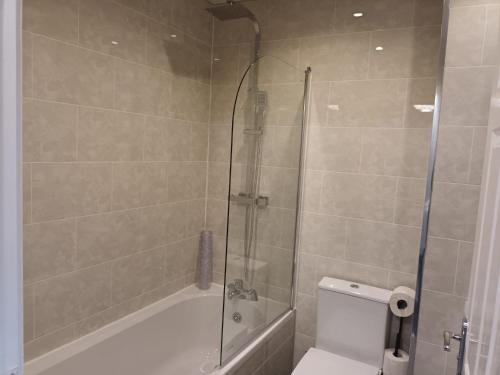 a bathroom with a shower and a toilet and a tub at 2 Bed House - Sleeps 6 - Parking - Wifi in Oldbury