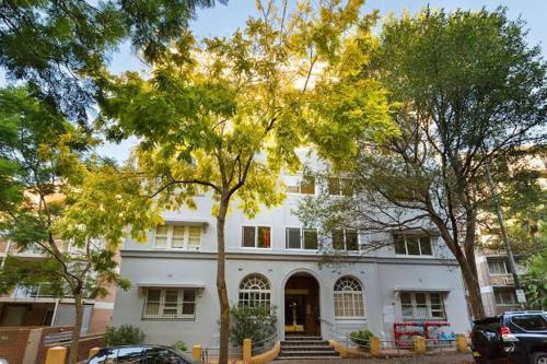a white house with trees in front of it at Luxury heritage Hideaway - close to CBD! in Sydney