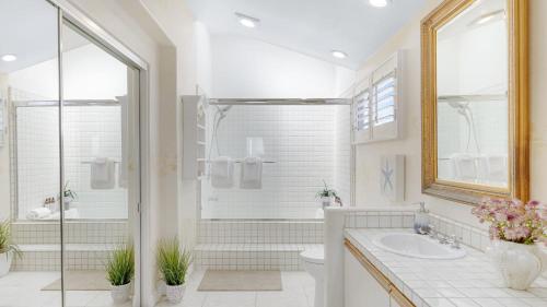 a white bathroom with a shower and a sink at Shoreline Villa by AvantStay Steps to the Beach Bay Pier in Newport Beach