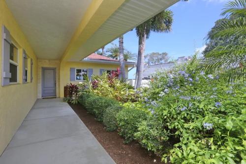 a walkway leading to a house with flowering plants at 8730 Dunmore Dr in Vamo