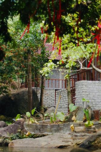 a brick building with red ribbons hanging from trees at Chez Vous House - Toom Sara in Mang Son