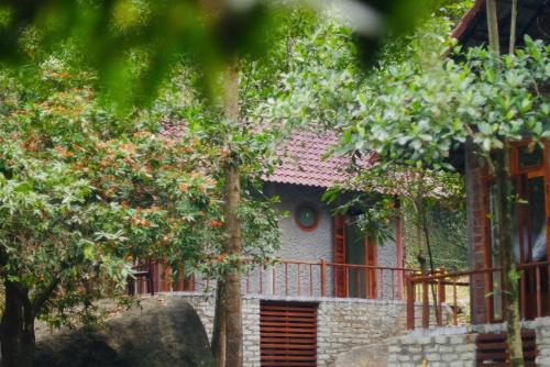 a house with a red fence and trees at Chez Vous House - Toom Sara in Mang Son