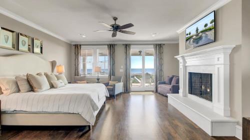 a bedroom with a large bed and a fireplace at 3100 Palm Boulevard by AvantStay Beachfront Ocean Views Private Pool in Isle of Palms