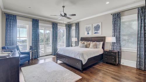 a bedroom with a bed and a couch and windows at 3100 Palm Boulevard by AvantStay Beachfront Ocean Views Private Pool in Isle of Palms