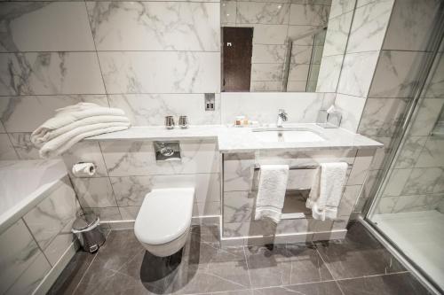 a white bathroom with a sink and a toilet at Parklands Hotel & Country Club in Newton Mearns