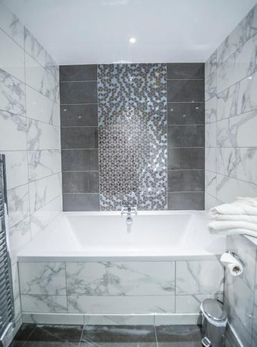 a bathroom with a tub and a shower at Parklands Hotel & Country Club in Newton Mearns
