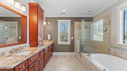 a bathroom with two sinks and a tub and a shower at Luxury Lakefront Stay Private Dock IndoorOutdoor Pool The Retreat in Terrell