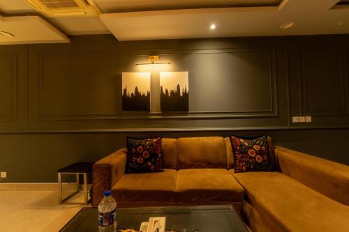 a living room with a couch and a table at Gold Crest Grand Executive Hotel Apartments DHA Lahore in Lahore