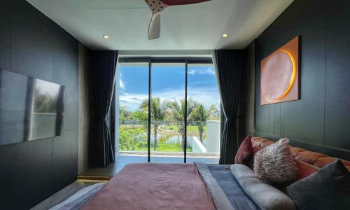 a bedroom with a bed and a large window at Sanctuary Villa in Ho Tram