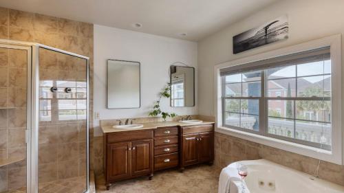 La salle de bains est pourvue d'une baignoire, de 2 lavabos et d'une douche. dans l'établissement Crabline Getaway by AvantStay Private Pool Hot Tub Easy Beach Access, à Île de Hilton-Head