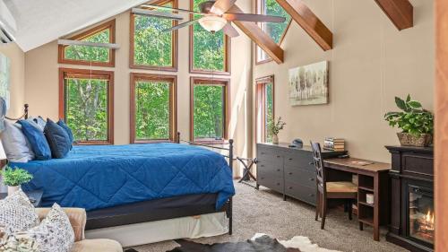 a bedroom with a blue bed and a desk and windows at The Great Escape by AvantStay Game Room in Albrightsville