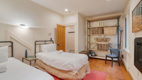 Un dormitorio con dos camas y una silla dentro. en Manitou River House 113 by AvantStay A Location, en Telluride