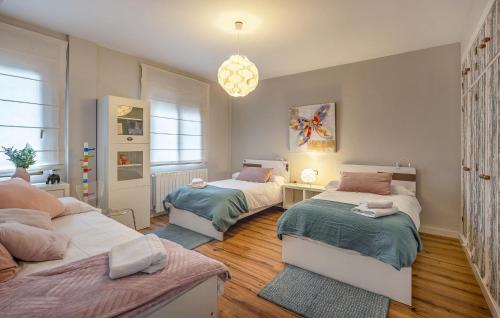 a bedroom with two beds and a chandelier at Beautiful Home In Illora in Illora
