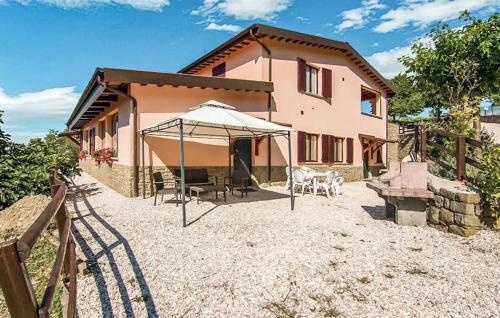 a house with an umbrella and a table and chairs at Country House Chiciabocca in Apecchio