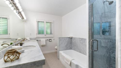 a white bathroom with a shower and a sink at East Valley Manor by AvantStay Minutes to the Beach in Montecito