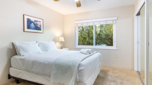 a white bedroom with a bed and a window at East Valley Manor by AvantStay Minutes to the Beach in Montecito