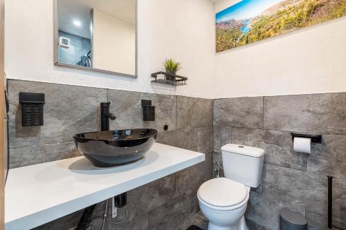 a bathroom with a sink and a toilet at Apartamentos cuna del Genil in Güéjar-Sierra
