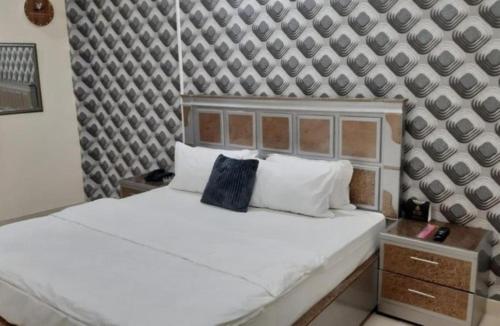 a bedroom with a white bed and a wall at Red Velvet Hotel & Restaurant in Dargai