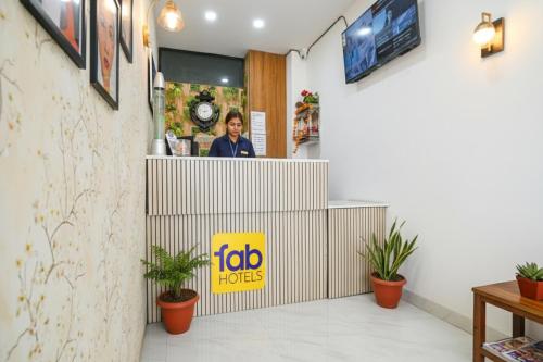 インドールにあるFabHotel Chirag Innのファーストフード店のカウンターに立つ女性