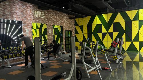 a gym with people working out in machines at Gold Crest Grand Executive Hotel Apartments DHA Lahore in Lahore