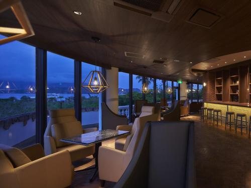 a restaurant with chairs and tables and windows at i + Land Nagasaki in Nagasaki