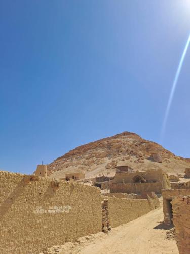 a dirt road in front of a mountain at Siwa Kenz in Siwa
