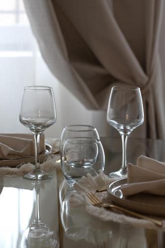 two wine glasses sitting on top of a table at Les Nuits en Grands Crus Coocon et soins Occitane in Ladoix Serrigny