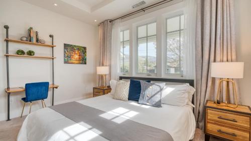 a bedroom with a bed and two windows at Luxe Pool Spa Fire Pit Game Room Piano Sonoma Pool Retreat by AvantStay in Kenwood