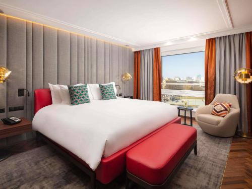 a hotel room with a large bed and a chair at Sofitel Warsaw Victoria in Warsaw