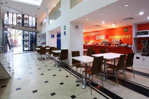 a dining area with tables and chairs in a restaurant at One Ciudad de Mexico Alameda in Mexico City