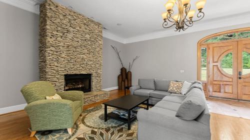 a living room with a couch and a fireplace at Whitetail Cove by AvantStay Lakefront w Pool Private Dock Sleeps 20 in Terrell