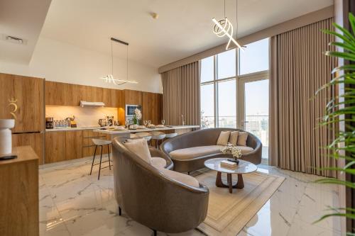 a kitchen and living room with chairs and a table at Elegant 4BR Escape - Masdar Chic Retreat in Abu Dhabi