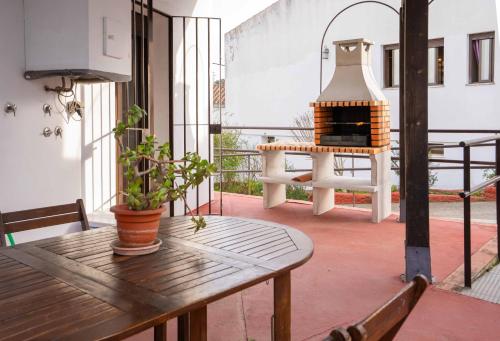 a patio with a table and a fireplace on a balcony at Casas Rurales Los Montes in La Corte