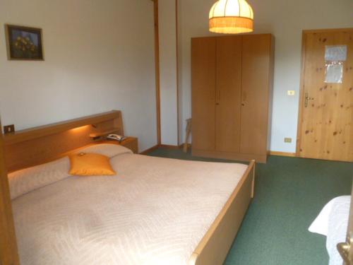 a bedroom with a large white bed with an orange pillow at Albergo Negritella in Borgo