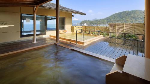 a house with a pool of water on a deck at Izu Mitohama Shotokan in Numazu
