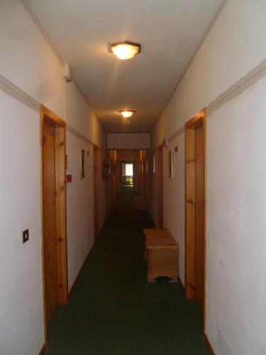 a hallway with a long corridor with wooden doors and a room at Albergo Negritella in Borgo