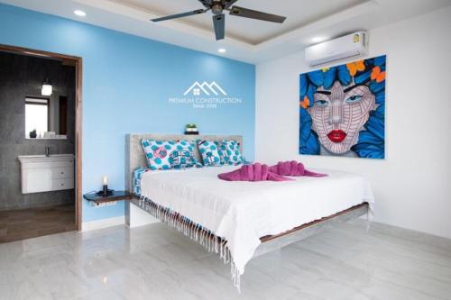 a bedroom with a large bed with a painting on the wall at Villa Ruby Samantha 2BR with Sea View in Amphoe Koh Samui