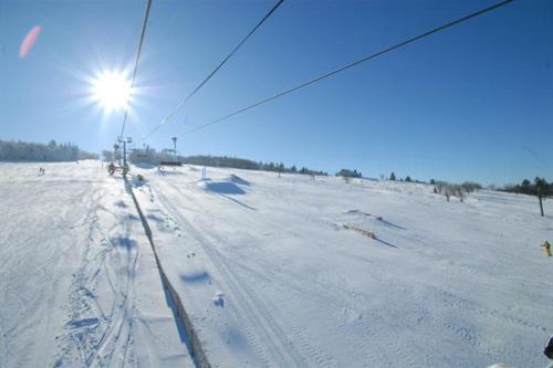 un campo cubierto de nieve con el sol en el cielo en Apartment With Balcony In Gérardmer, en Gérardmer