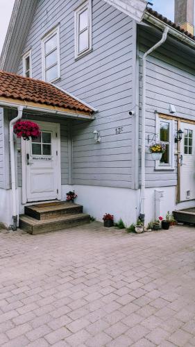 a gray house with a white door and stairs at Mikael's Bed & Spa apartment in Sandefjord